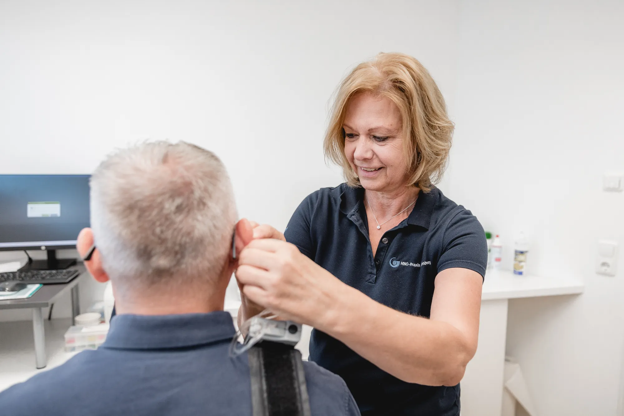 MFA führt bei einem Patienten eine Messung am Ohr durch.